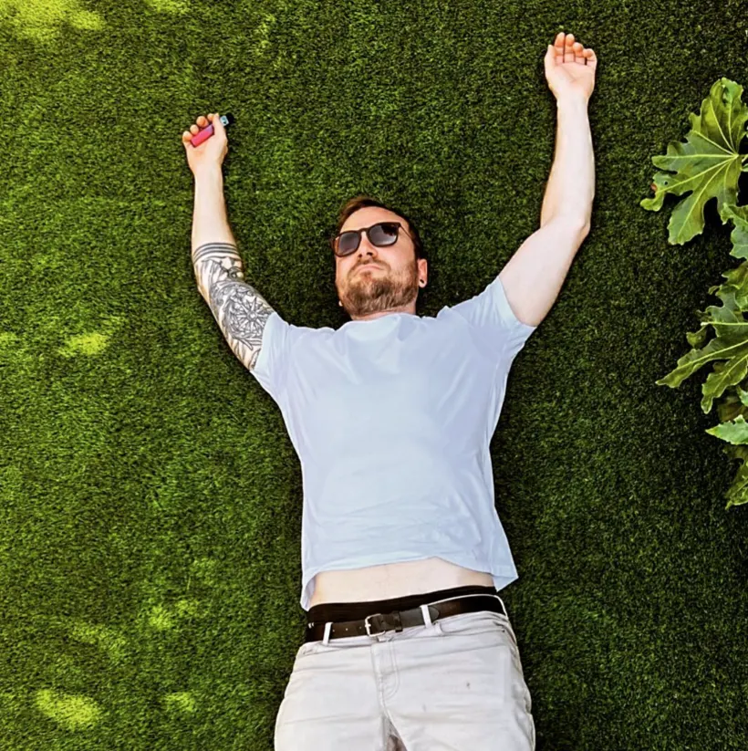 Michael lying back on a sunlit lawn