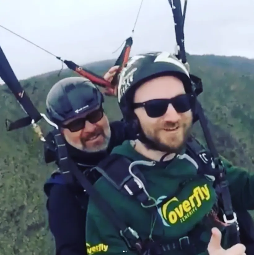Michael paragliding in tandem over hills