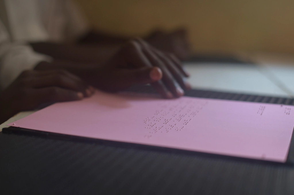Fingers reading a line of braille