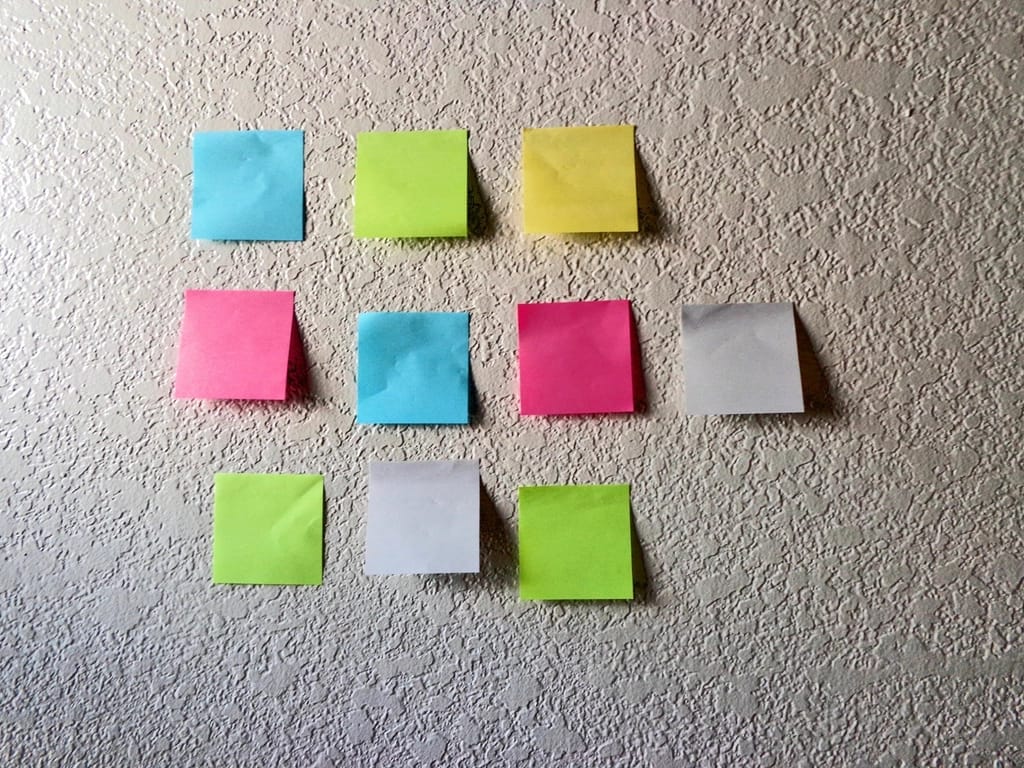 Coloured sticky notes arranged in a grid on a wall