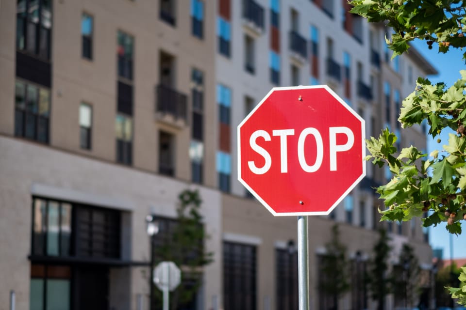 A red stop sign on a street in front of apartment buildings