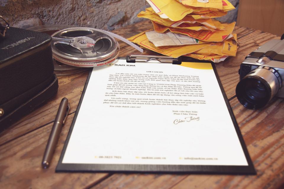 A printed document on a clipboard with a pen and papers on a desk