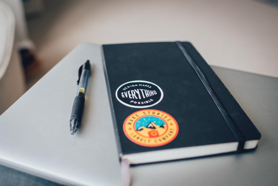 A planner and notebook open on a desk