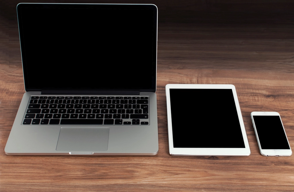 A laptop, tablet and phone on a desk