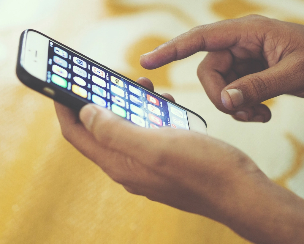 A hand holding a smartphone showing an app
