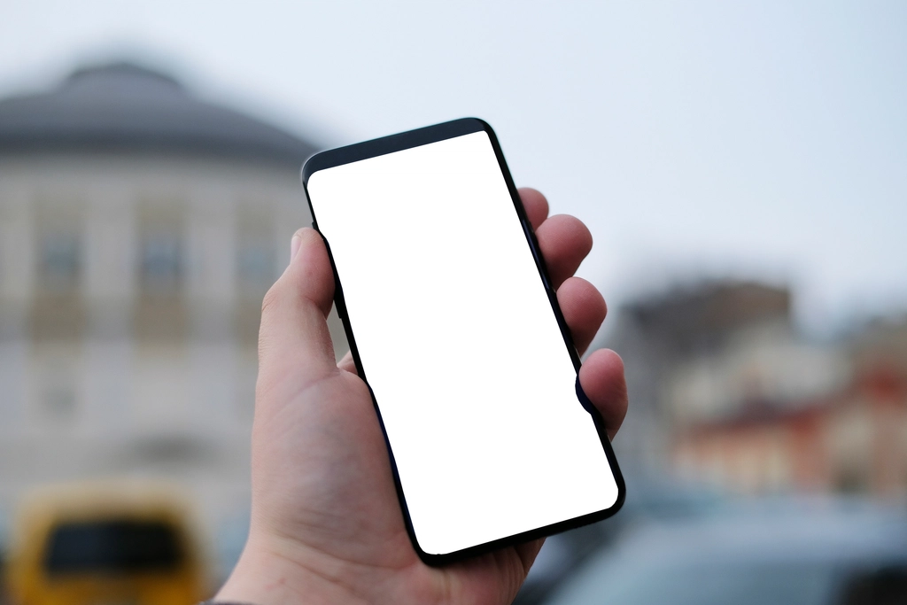 A hand holding a smartphone showing an app screen