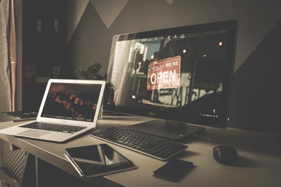 A laptop, tablet and phone on a desk