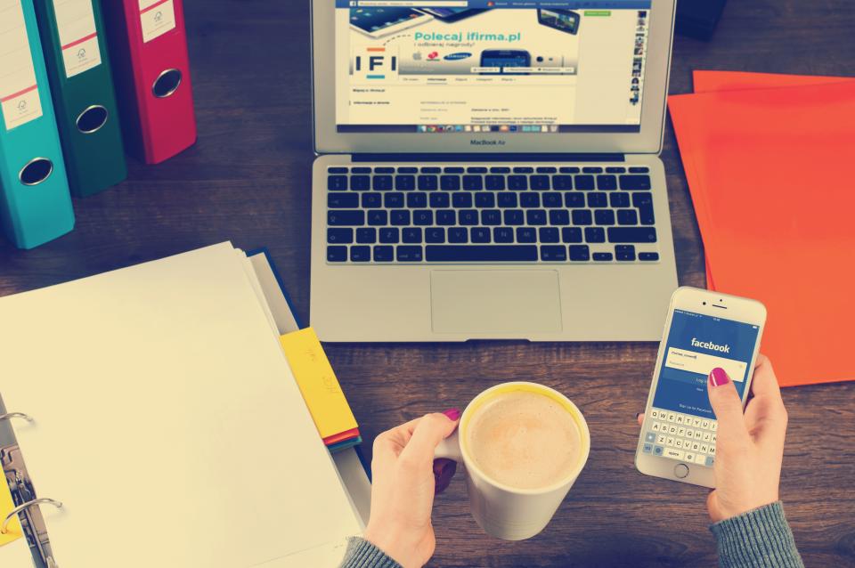 A phone and laptop side by side on a desk