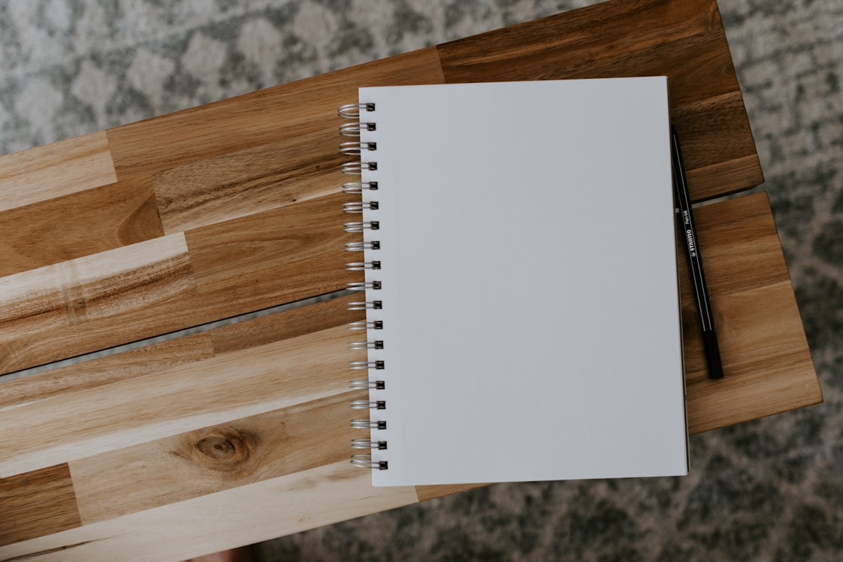 A spiral notebook on a wooden desk