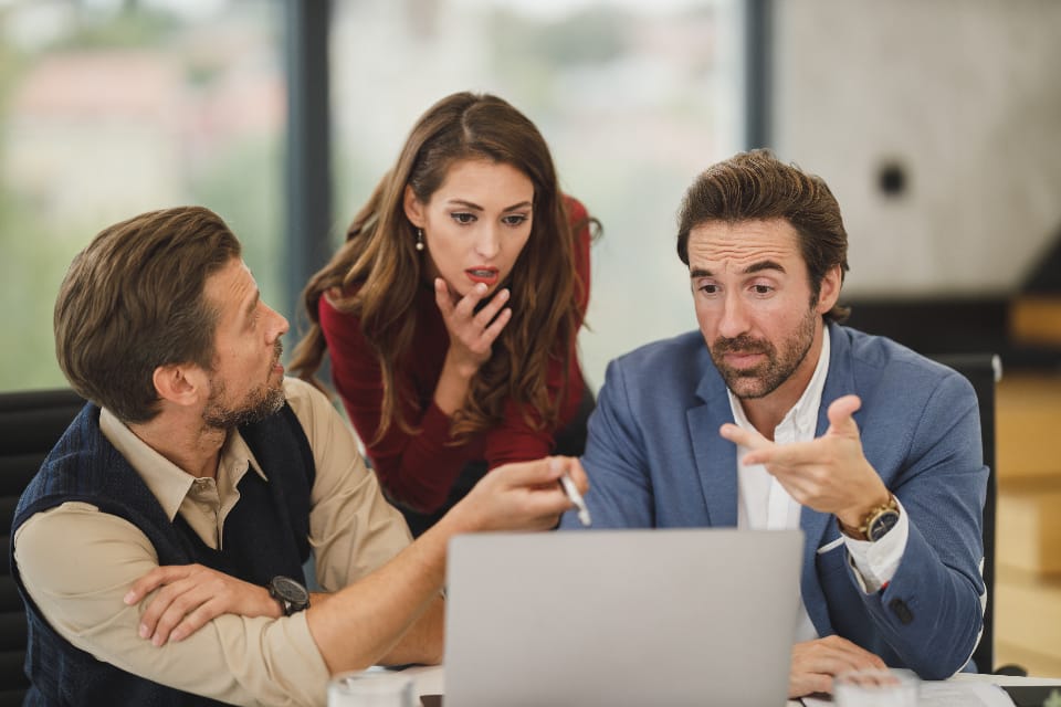 A team in discussion at a laptop