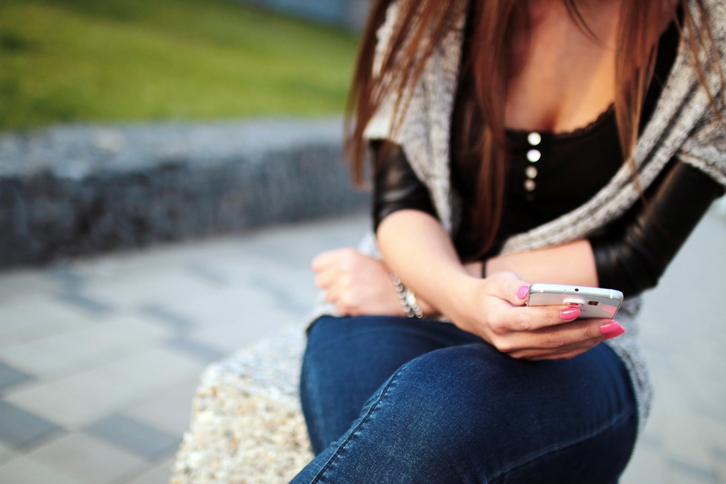 A woman using a smartphone on a city street