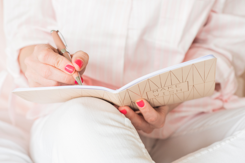 A hand writing notes in a notebook